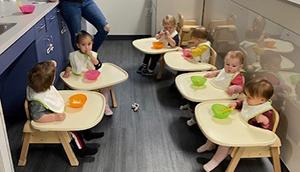 Infants sitting in high chairs at snack time